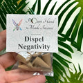 Crystal Fairy Patch Dispel Negativity handmade cone incense pack for clearing negative energy, held in hand against green leaves