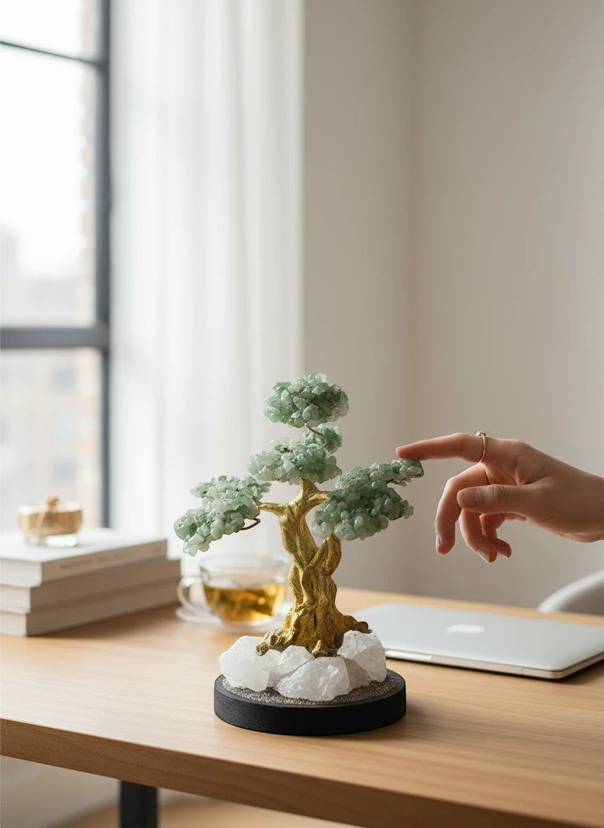 Crystal Fairy Patch jade bonsai tree with green gemstone leaves, gold trunk, and quartz crystal base on a wooden desk.