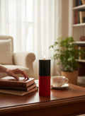Crystal Fairy Patch handcrafted double action reversing candle with black and red wax on a wooden table in a cozy living room.