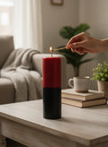 Crystal Fairy Patch handcrafted double action reversing candle in red and black being lit on a wooden table in a cozy living room