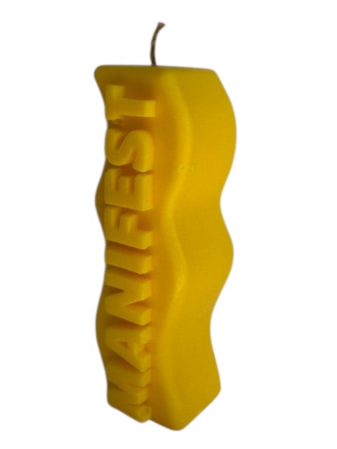 Crystal Fairy Patch yellow handcrafted sculptural candle with a wavy silhouette and raised MANIFEST lettering.