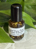 Crystal Fairy Patch Spring Equinox Ostara ritual oil in a small glass bottle with botanical herbs, set against green leaves.