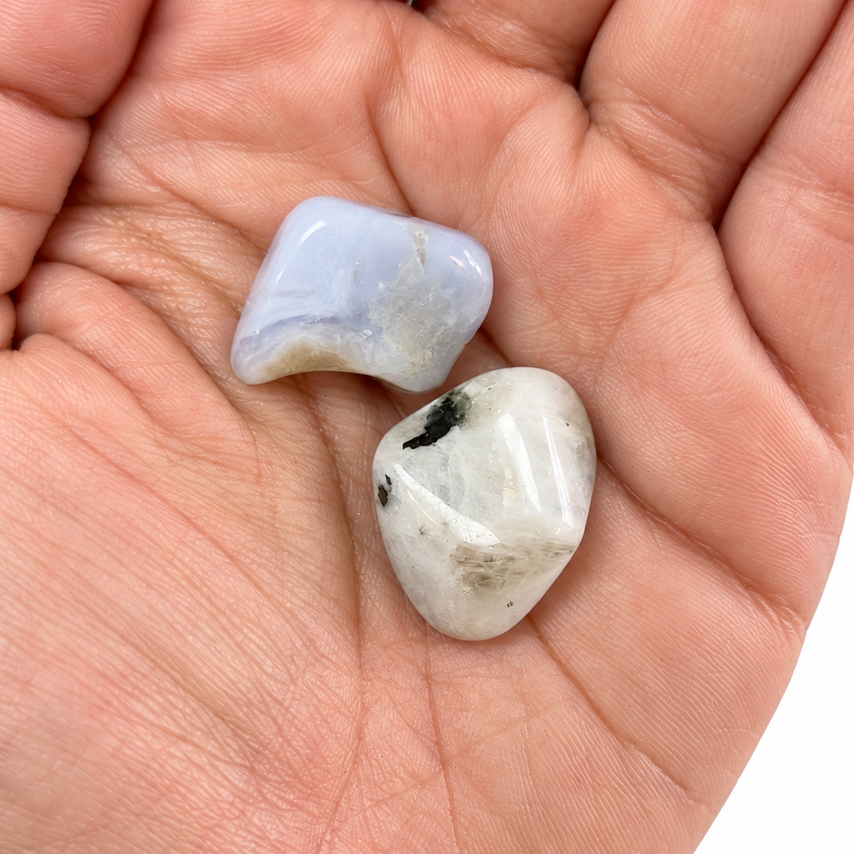 Rainbow Moonstone and Blue Chalcedony shown close up in an open palm