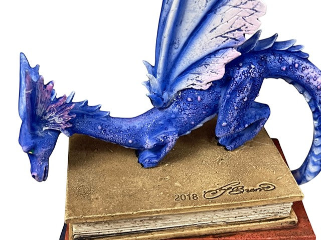 My Store Indigo Book Dragon figurine with iridescent scales and purple/pink wings perched on antique books.