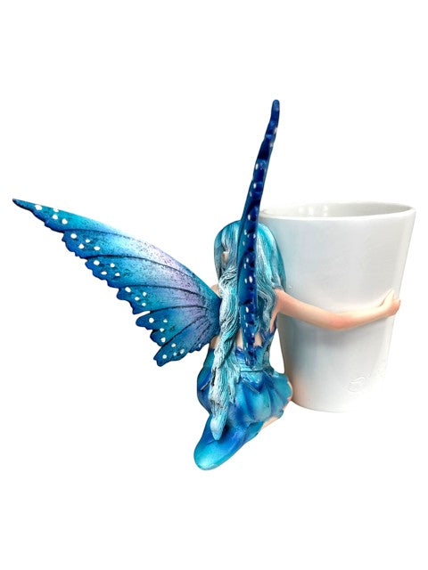 My Store blue fairy figurine with white polka dots on wings, hugging a white coffee cup.