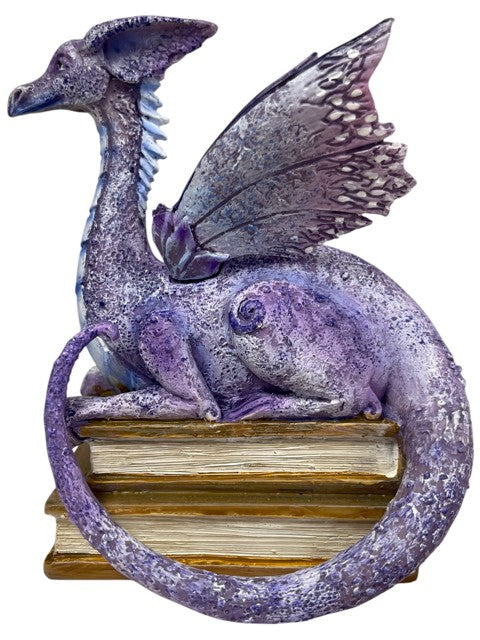 My Store lavender, purple, and blue dragon figurine perched on a stack of antique books.