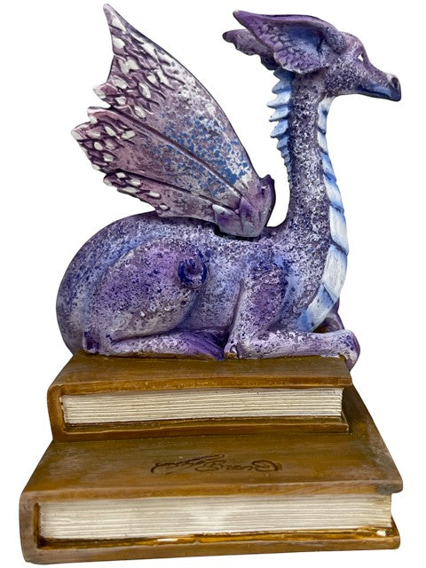 My Store lavender, purple, and blue dragon figurine perched on stack of antique books. Detailed wings and serene expression.