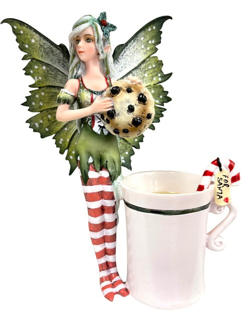 My Store Amy Brown fairy figurine holding a chocolate chip cookie next to a white mug with a candy cane and 'For Santa' tag.