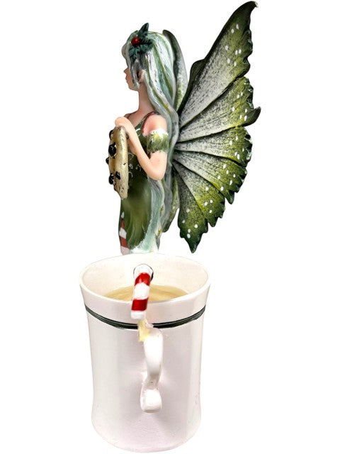 My Store Amy Brown "Fairy Christmas" mug with a fairy holding a cookie and a candy cane stirrer.