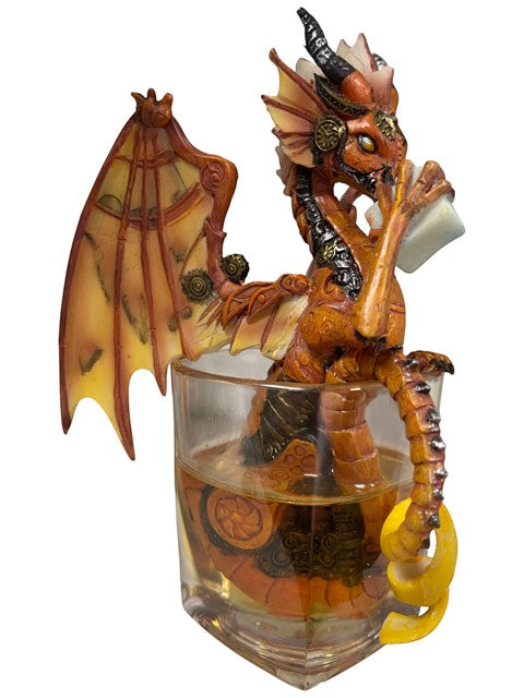 My Store Steampunk dragon figurine with orange and gold wings, sitting in a glass of amber liquid with a lemon peel.