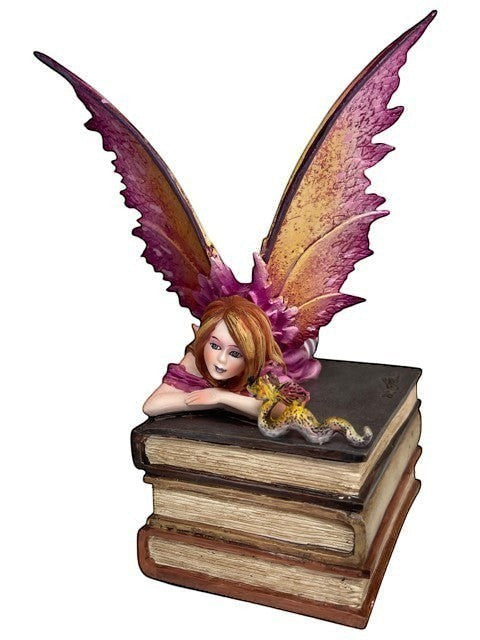 My Store Book Club Fae figurine of a fairy with purple and gold wings resting on a stack of antique books.