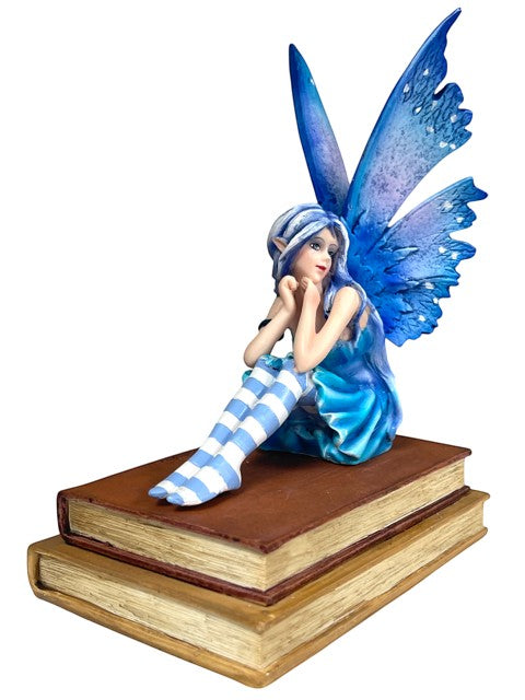 My Store Book Muse Fairy Figurine with blue hair, blue butterfly wings, and blue dress, sitting on two brown books.