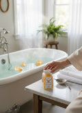 My Store Crystal Fairy Patch Gold Light Bath Salts in a clear jar with yellow crystals, next to a steaming bathtub.