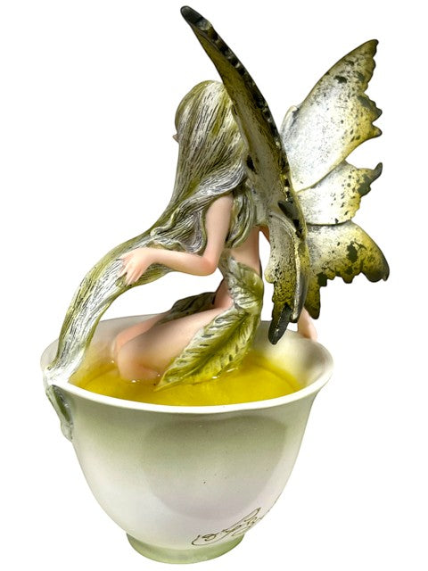 My Store Green Tea Fairy figurine by Amy Brown Art, sitting in a teacup filled with light green liquid.