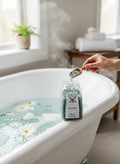 My StoreHere Crystal Fairy Patch Aventurine Bath Salts in a jar next to a bathtub with flowers and steam.
