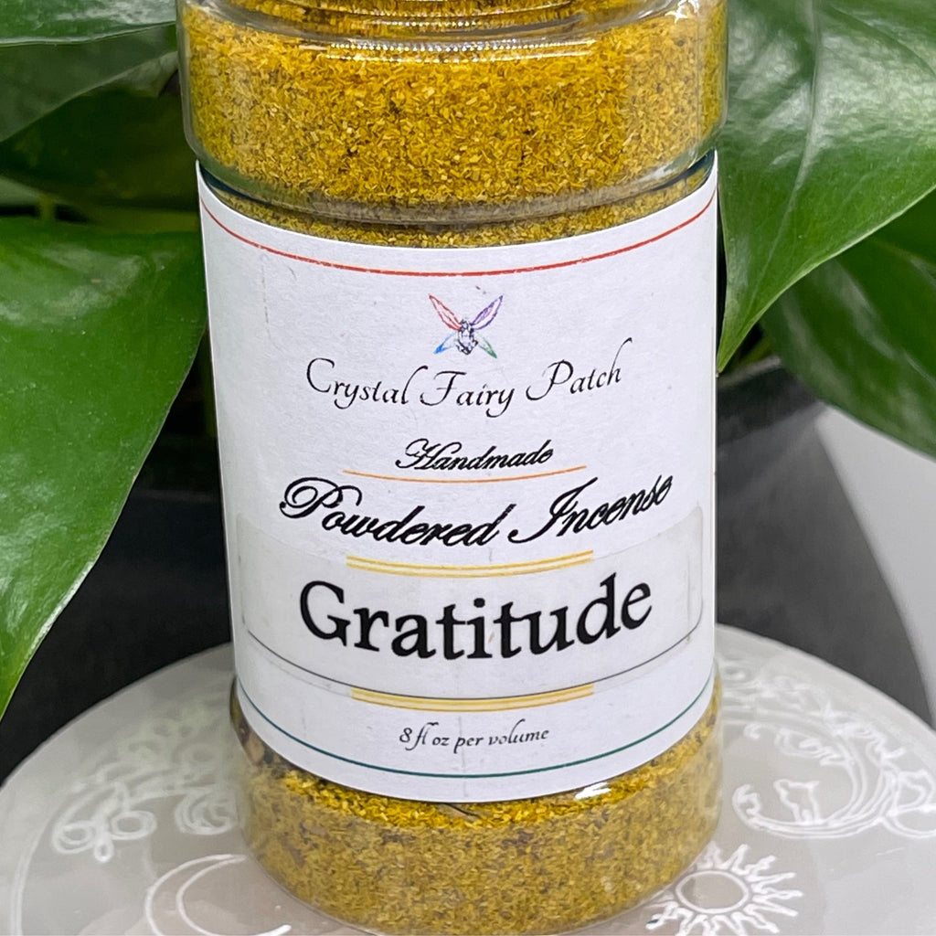 My Store Gratitude powdered incense in a clear jar with a white label. Yellow-gold granular incense.