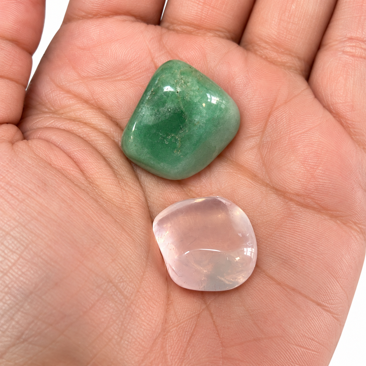 Rose Quartz and Green Aventurine shown close up in an open palm